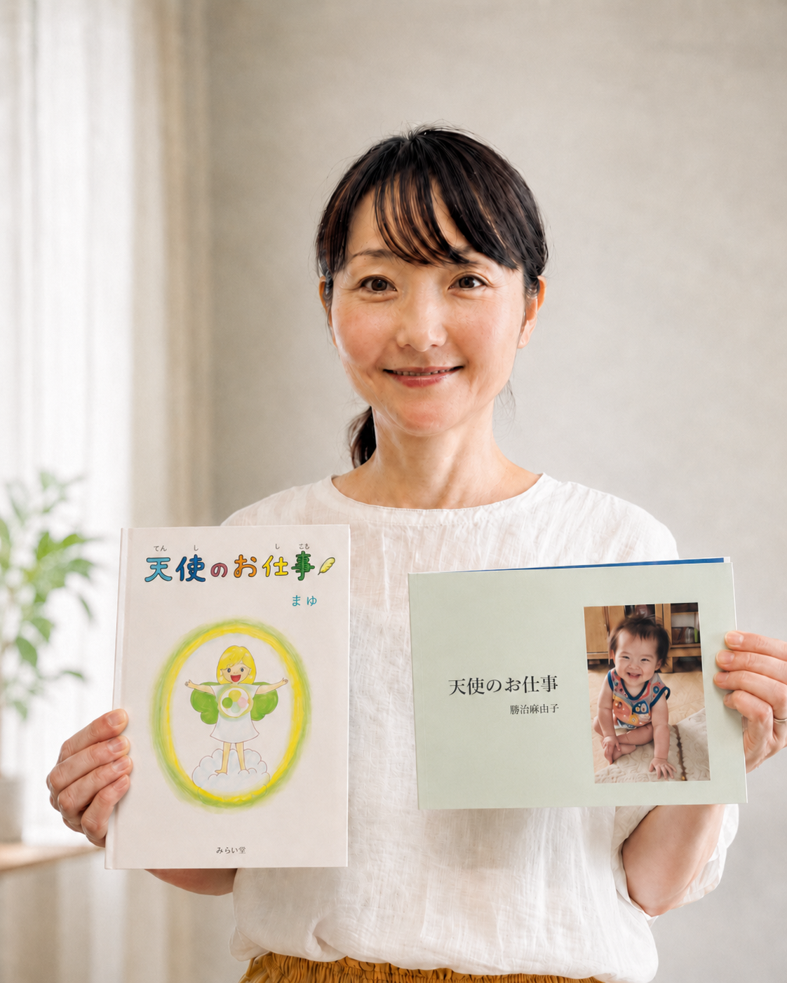 絵本を手にほほえむ講師・勝治麻由子の写真